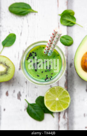 Bicchiere di frullato verde con avocado, spinaci, kiwi e lime Foto Stock