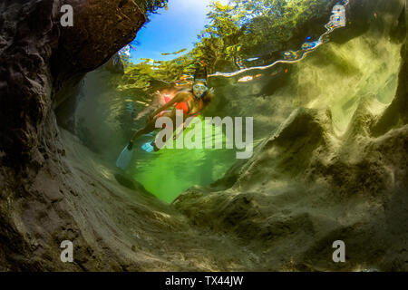 Austria, Salzkammergut, giovane donna snorkeling nel fiume di montagna Weissenbach Foto Stock