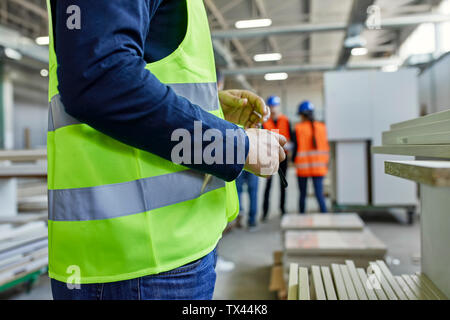 Close-up del Lavoratore che indossa giubbotto in fabbrica Foto Stock