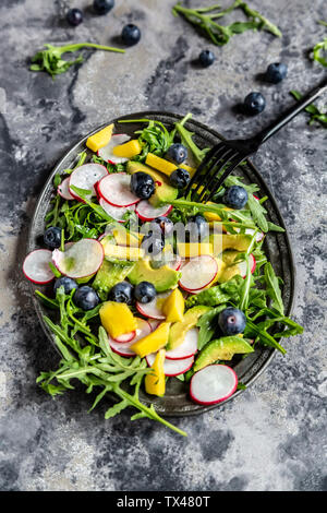 Piatto di insalata di rucola con mango, avocado, rosso ravanelli e mirtilli Foto Stock