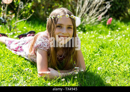 Ritratto di felice ragazza distesa sul prato in giardino Foto Stock