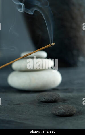 Joss stick e impilata ciottoli bianchi Foto Stock