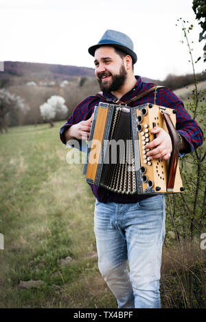 Ritratto di uomo barbuto di fisarmonica su un prato Foto Stock