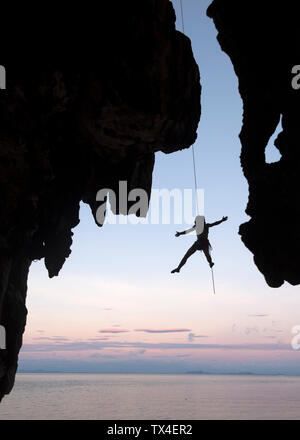 Thailandia, Krabi, Lao Liang island, scalatore la discesa in corda doppia dalla parete di roccia sopra il mare Foto Stock