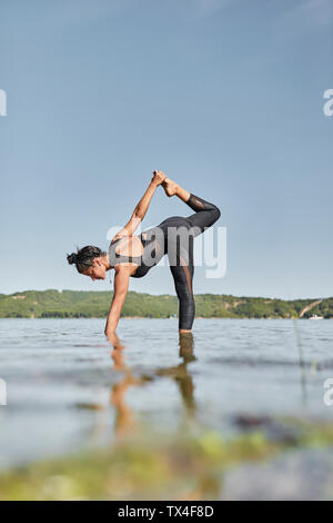 Giovane donna fare yoga nella natura Foto Stock