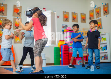 I bambini con gli occhiali VR giocando in kindergarten Foto Stock