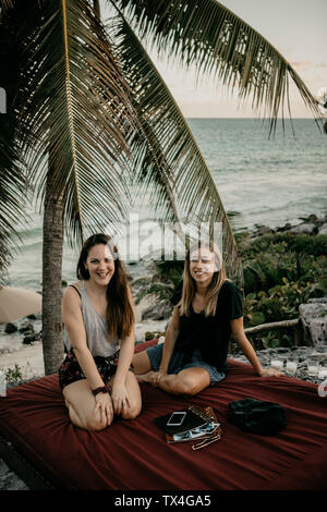 Messico, Quintana Roo, Tulum, felice di due giovani donne rilassante sulla spiaggia Foto Stock