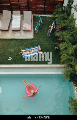 Due giovani donne di relax presso la piscina Foto Stock