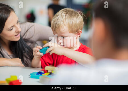 Pre-insegnante di scuola a giocare con il bambino in asilo nido Foto Stock