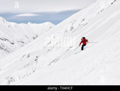 Georgia e Caucaso, Gudauri, uomo su un tour di sci equitazione in discesa Foto Stock