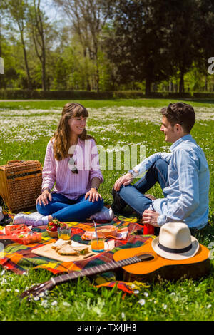 Coppia giovane avente un pic-nic con cibi sani in un parco Foto Stock