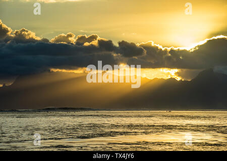 Polinesia francese, Tahiti, Sunray rottura attraverso le nuvole sopra Moorea Foto Stock