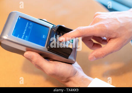 Uomo che utilizza un lettore di carte di credito, close-up Foto Stock