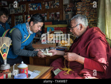 Il Nepal, Sherpa ottenendo una benedizione da moch prima di salire egli Mount Everest Foto Stock