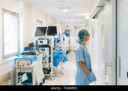 Medico donna in piedi nel corridoio dell'ospedale, la preparazione per la chirurgia Foto Stock