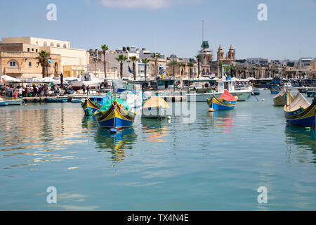 Luzzas e altre barche da pesca maltesi ormeggiata nel porto di Marsaxlokk a Malta Foto Stock