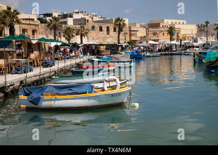 Barche da pesca ormeggiate lungo la banchina a Marsaxlokk a Malta Foto Stock