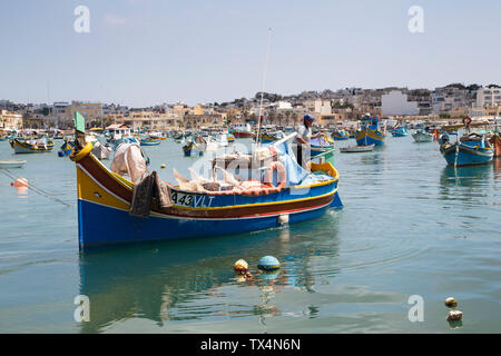 Luzzas e altre barche da pesca maltesi ormeggiata nel porto di Marsaxlokk a Malta Foto Stock