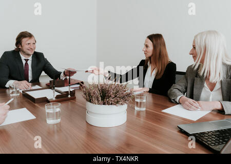 Imprenditrice consegna carta al collega durante una riunione nella sala conferenze Foto Stock
