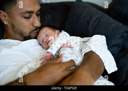 Padre cuddling con neonato sul lettino Foto Stock