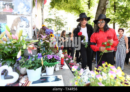 Monaco di Baviera, Germania. Il 24 giugno 2019. Il esecutori musicali Dantanio Goodman (l) e Koffi Missah fiori laici al memoriale per il decimo anniversario della morte di Michael Jackson presso il monumento a Jackson. I creatori di Jackson musical 'Beat it' invitato amici e compagni di Bayerischer Hof, dove il Re del Pop" vissuto quando era a Monaco di Baviera. Credito: Tobias Hase/dpa/Alamy Live News Foto Stock