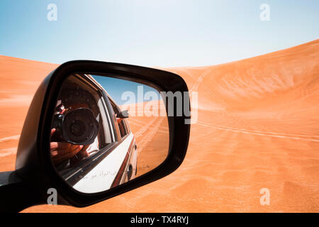 L'immagine speculare di un uomo di scattare le foto da un veicolo fuoristrada, Oman, Wahiba Sands Foto Stock