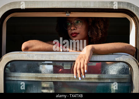 Donna che guarda fuori della finestra del treno Foto Stock