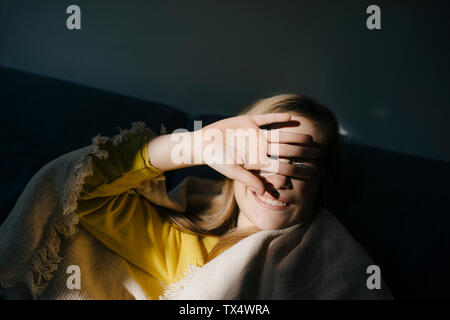 Ragazza alla schermatura di casa i suoi occhi dal sole Foto Stock