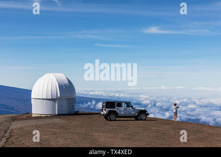 Stati Uniti d'America, Hawaii, Mauna Kea vulcano, donna di fronte fuoristrada a observatory Foto Stock