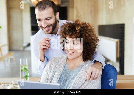 Felice l'uomo e donna tablet Condivisione in ufficio moderno Foto Stock