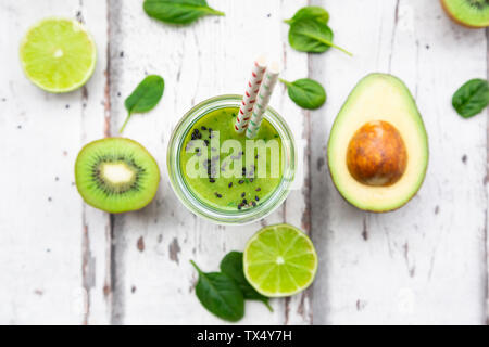 Bicchiere di frullato verde con avocado, spinaci, kiwi e lime Foto Stock