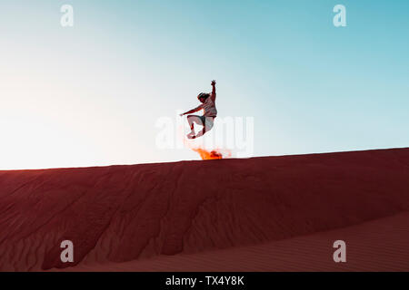 Il sultanato di Oman, Wahiba Sands, metà uomo adulto è il gioco con la sabbia nel deserto Foto Stock