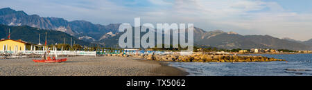 Serata tranquilla sulla spiaggia di Marinella, Massa Carrara, Italia. La stazione bagnino è deserta. Le Alpi Apuane si vede in background. Foto Stock