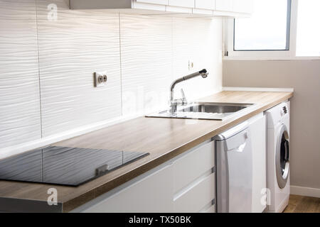 Bianco cucina moderna con arredamento bianco e pavimento in legno Foto Stock