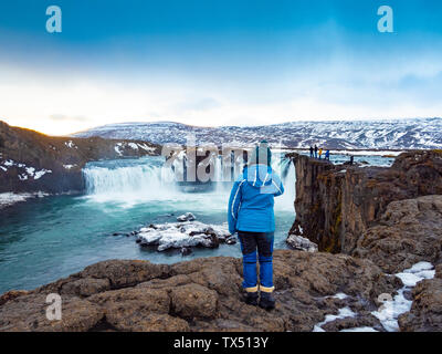 L'Islanda, la donna a cascata Godafoss in inverno Foto Stock