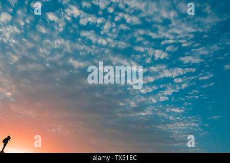 Uomo di scattare foto al tramonto, Oman Foto Stock