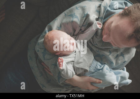 Vista superiore del padre tenendo la sua sleeping neonato figlia Foto Stock