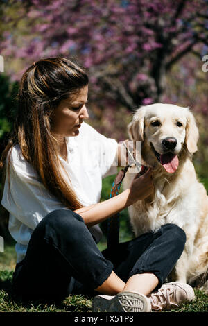 Donna e Labrador Retriever seduto sul prato in city park Foto Stock