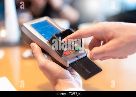 Uomo che utilizza un lettore di carte di credito, close-up Foto Stock