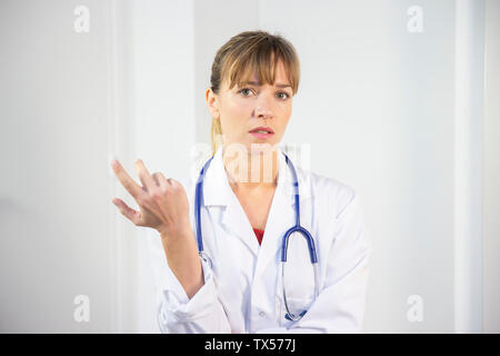 Un medico di sesso femminile nel suo mantello bianco Foto Stock