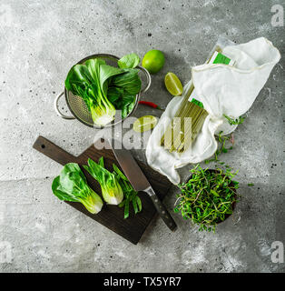 Ingredienti per la cottura piatto asiatico: bok choi, matcha tagliatelle, tigli, germogli su sfondo grigio Foto Stock