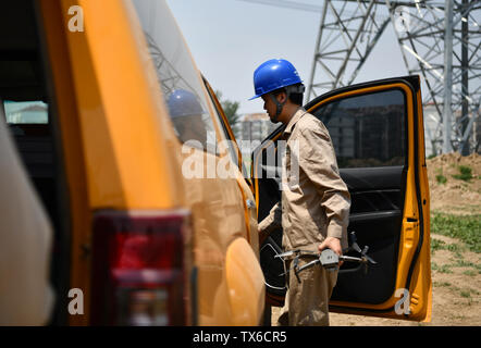 (190624) -- TIANJIN, Giugno 24, 2019 (Xinhua) -- Un ingegnere tiene fuori il fuco per ispezionare le linee elettriche in alta tensione nel nord della Cina di Tianjin, Giugno 24, 2019. (Xinhua/Li Ran) Foto Stock