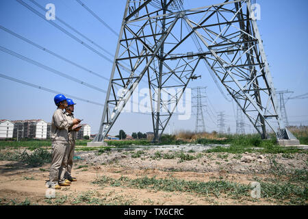 (190624) -- TIANJIN, Giugno 24, 2019 (Xinhua) -- Un ingegnere opera un drone per ispezionare le linee elettriche in alta tensione nel nord della Cina di Tianjin, Giugno 24, 2019. (Xinhua/Li Ran) Foto Stock