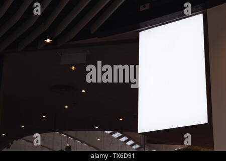 Schermata bianca vuota di segnaletica verticale mockup appesa al soffitto. Cartello pubblicitario design in un centro commerciale, galleria. Foto Stock