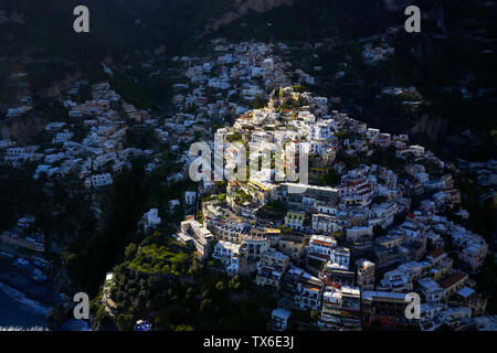 Paesaggio mozzafiato di Positano serale cittadina sulla costa di Amalfi in Italia. Ci sono molte case variopinte sulle verdi colline. La luce del sole cade sulla Foto Stock