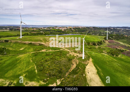 Mozzafiato paesaggio verde con diversi generatori di vento e pannelli solari sul campo con strade di campagna sullo sfondo con cielo nuvoloso in Italia. Antenna Foto Stock