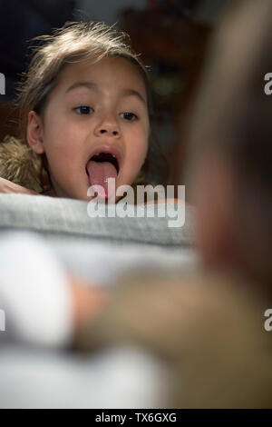 Incantevole piccola ragazza asiatica guardando nello specchio mostra del divario tra i suoi denti di latte come lei sta cambiando i denti Foto Stock