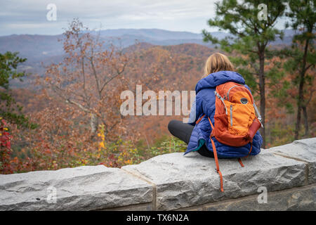 Una donna anziana con un back pack su prende le immagini delle montagne in autunno. Foto Stock