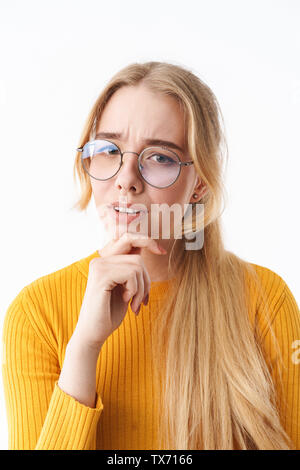 Attraente pensieroso giovane donna bionda che indossa un maglione in piedi isolato su sfondo bianco Foto Stock