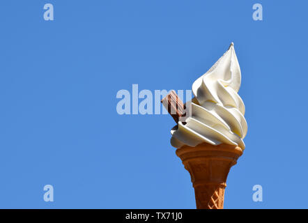 Soft frusta di gelato alla vaniglia in un cono con scaglie di cioccolato Foto Stock